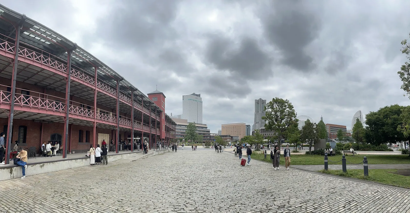 The broad pedestrian plaza beside Yokohama Red Brick Warehouse, with waterfront city landmarks in the distance