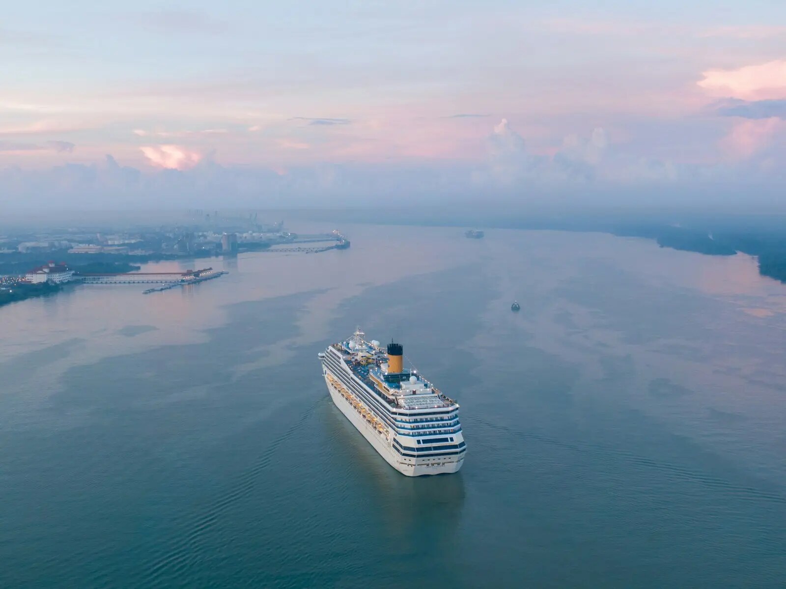 Cruise ship approaching a connected modern port